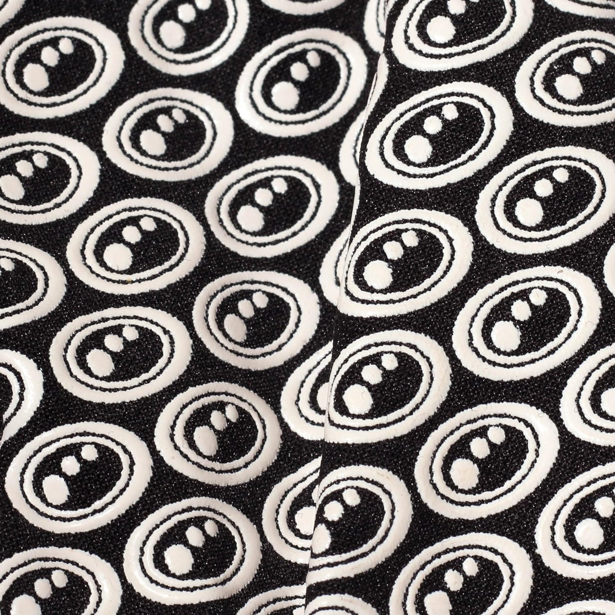Extreme close-up of black Optimum Stik Mits glove fabric showing raised white oval silicone grip print - Optimum